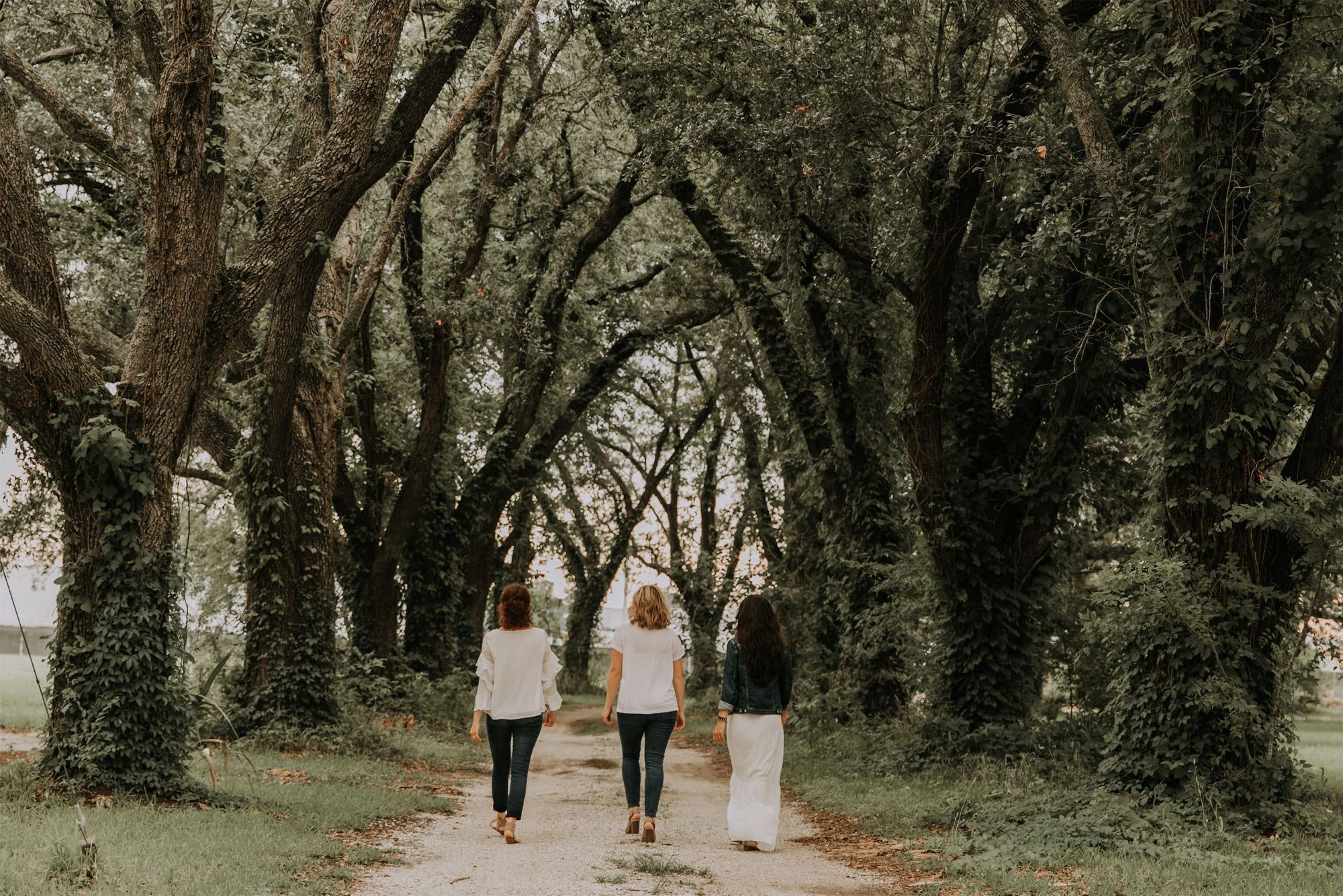 Kara Klein Oubre, Christine Simpson Wessa, and Maria Spears on a path near trees walking away from the camera