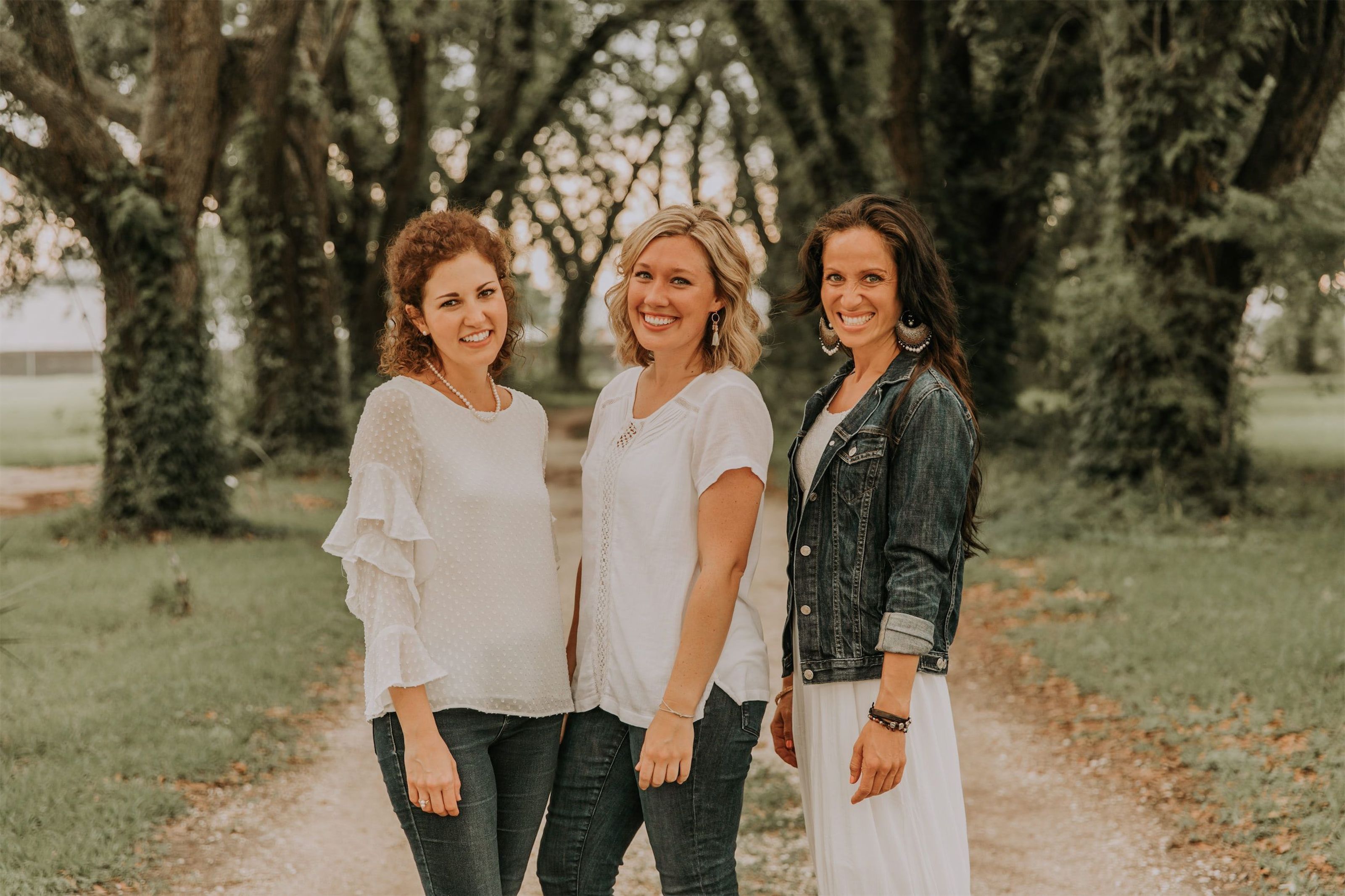 Kara Klein Oubre, Christine Simpson Wessa, and Maria Spears on a path near trees posing together variation one