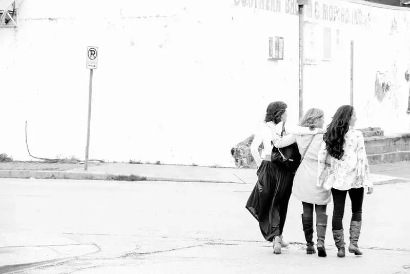 The ladies of His Own crossing the street in a black and white photo