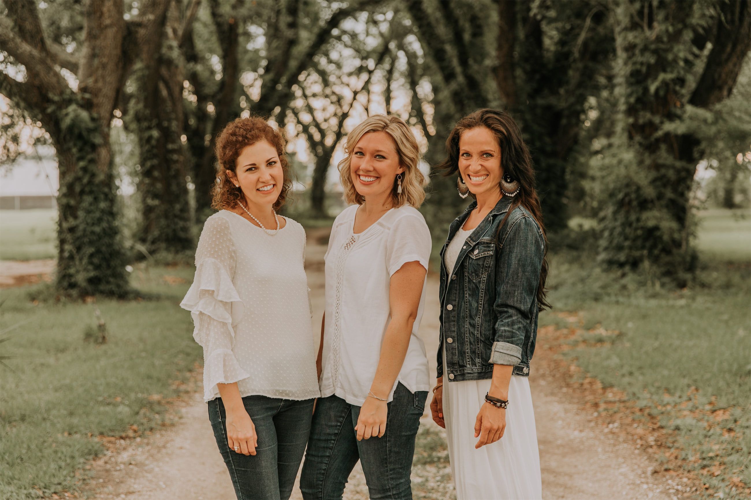 Kara Klein Oubre, Christine Simpson Wessa, and Maria Spears on a path near trees posing together variation one
