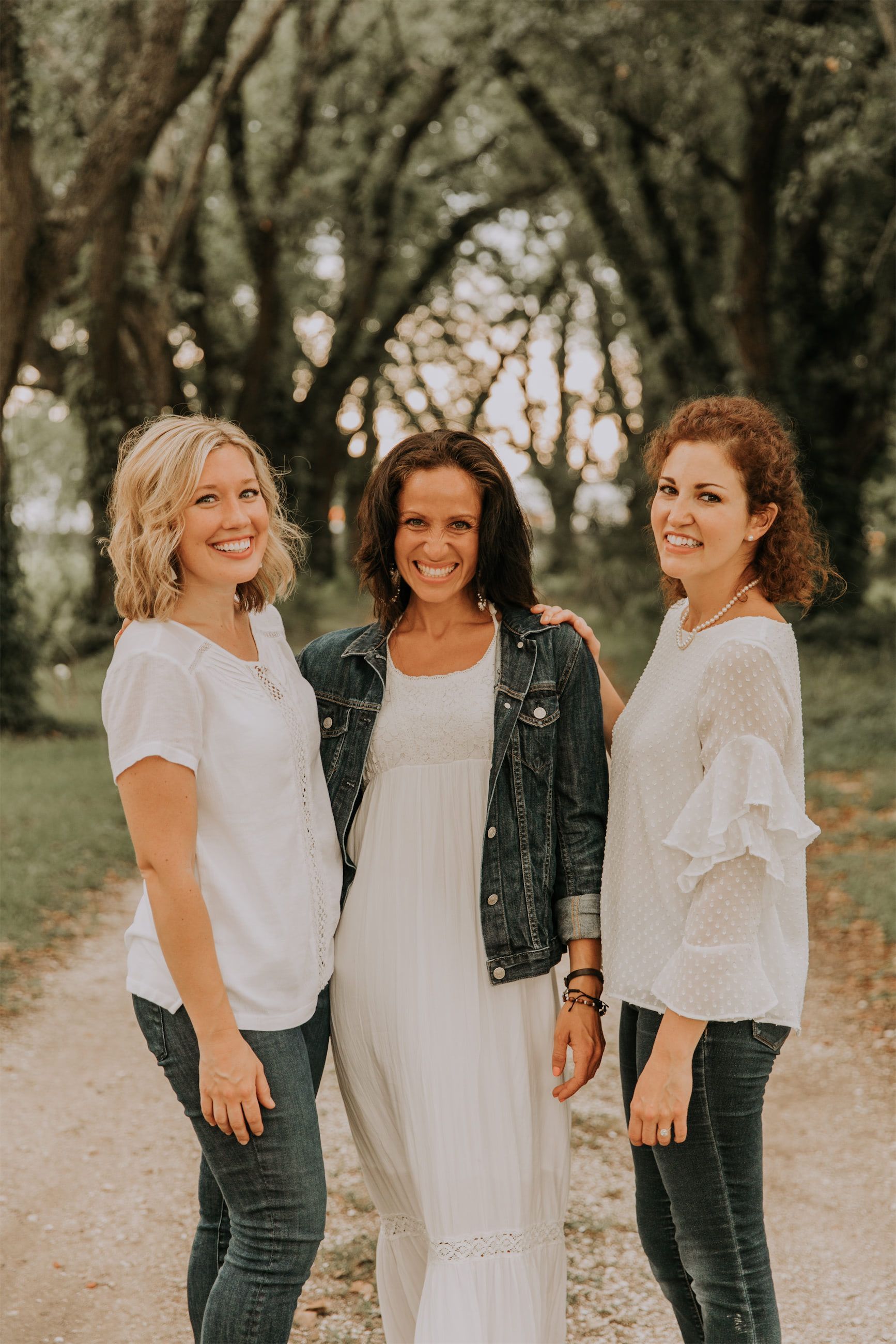 Kara Klein Oubre, Christine Simpson Wessa, and Maria Spears on a path near trees posing together variation three