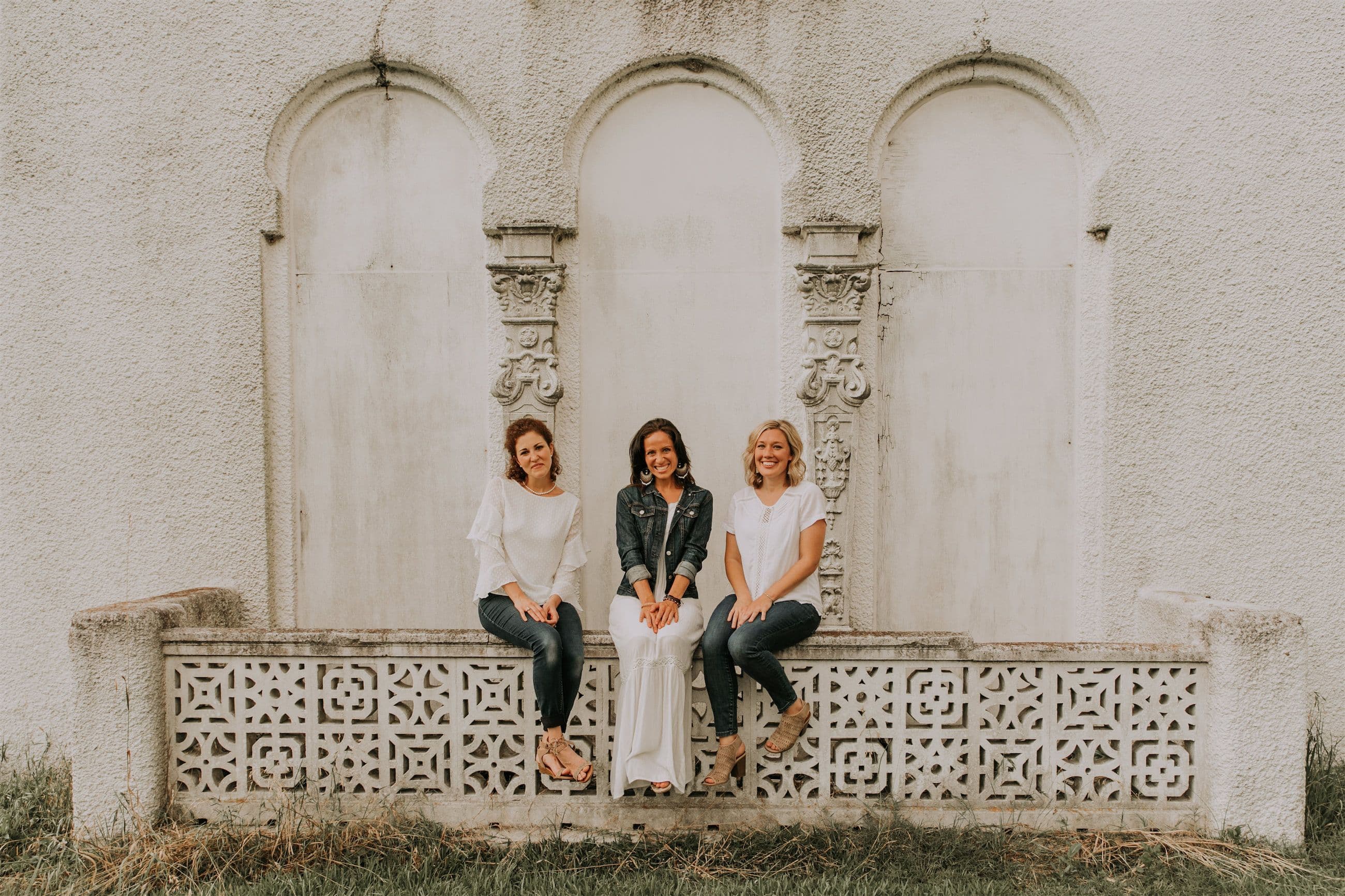 Kara Klein Oubre, Christine Simpson Wessa, and Maria Spears in front of a white stone background sitting